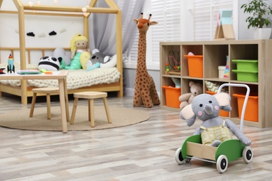 Photo of Cute child's room interior with toys and wooden furniture