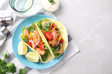 Photo of Yummy fish tacos served on marble table, flat lay. Space for text