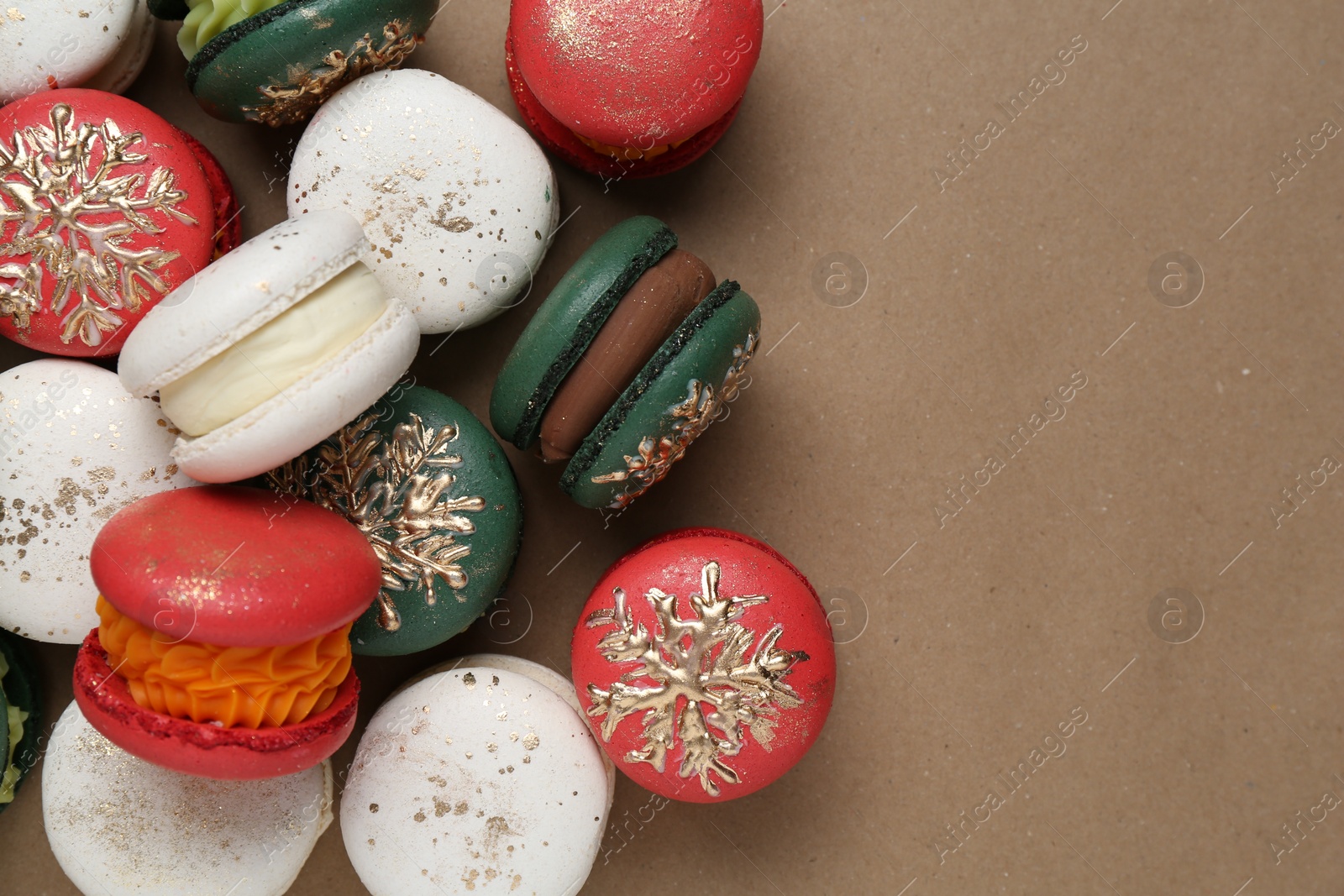 Photo of Beautifully decorated Christmas macarons on brown background, top view. Space for text