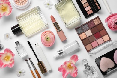 Photo of Flat lay composition with different makeup products and beautiful spring flowers on white background