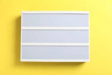Blank letter board on yellow background, top view