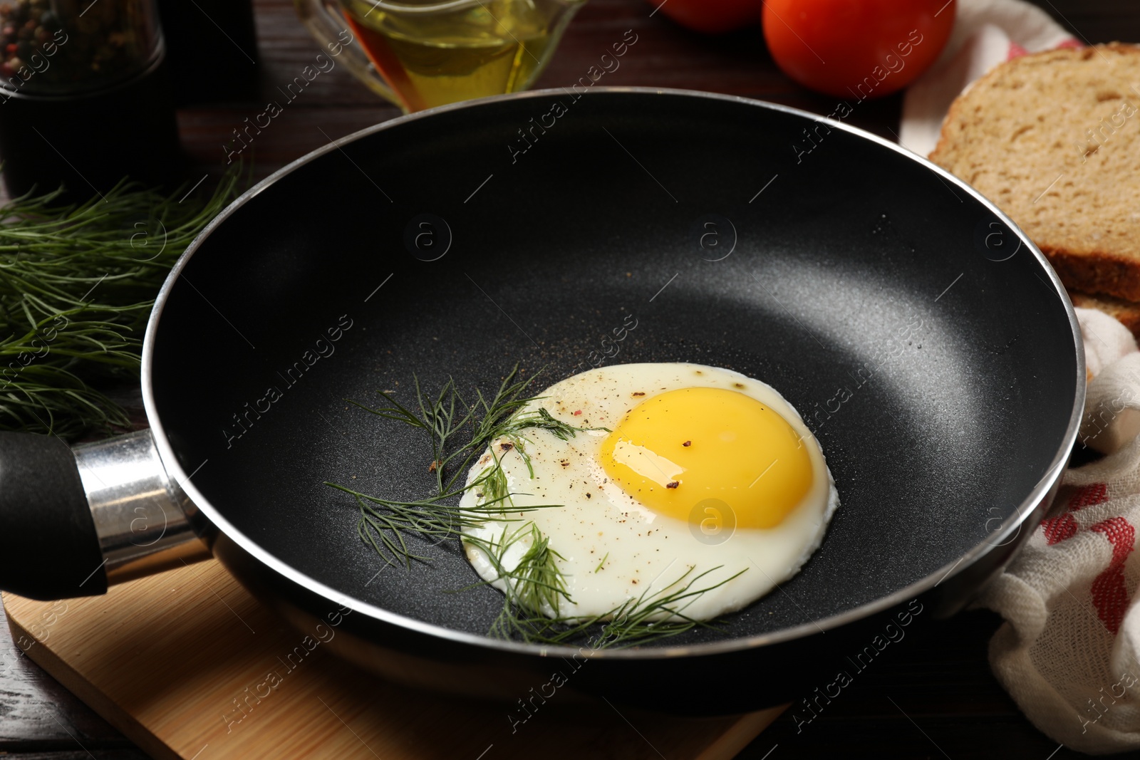 Photo of Delicious fried egg in frying paan on wooden table, closeup