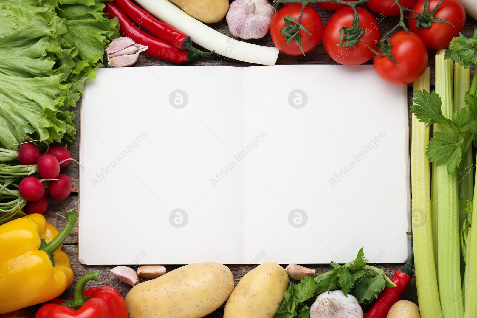 Photo of Blank recipe book and different ingredients on wooden table, flat lay. Space for text