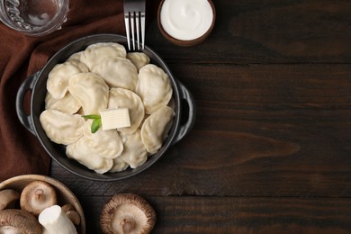 Photo of Serving pan of delicious dumplings (varenyky) with mushrooms on wooden table, flat lay. Space for text