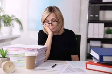 Overwhelmed woman sitting at table in office