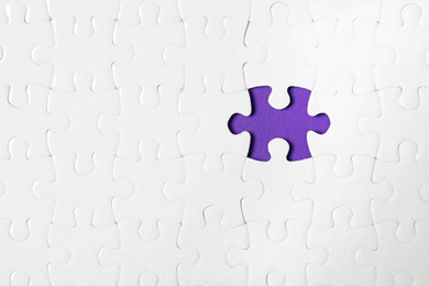 Photo of Blank white puzzle with missing piece on purple background, top view. Space for text