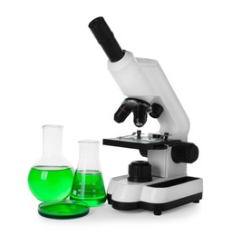 Laboratory glassware with green liquid and microscope isolated on white