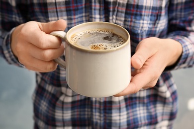 Man with cup of aromatic hot coffee, closeup