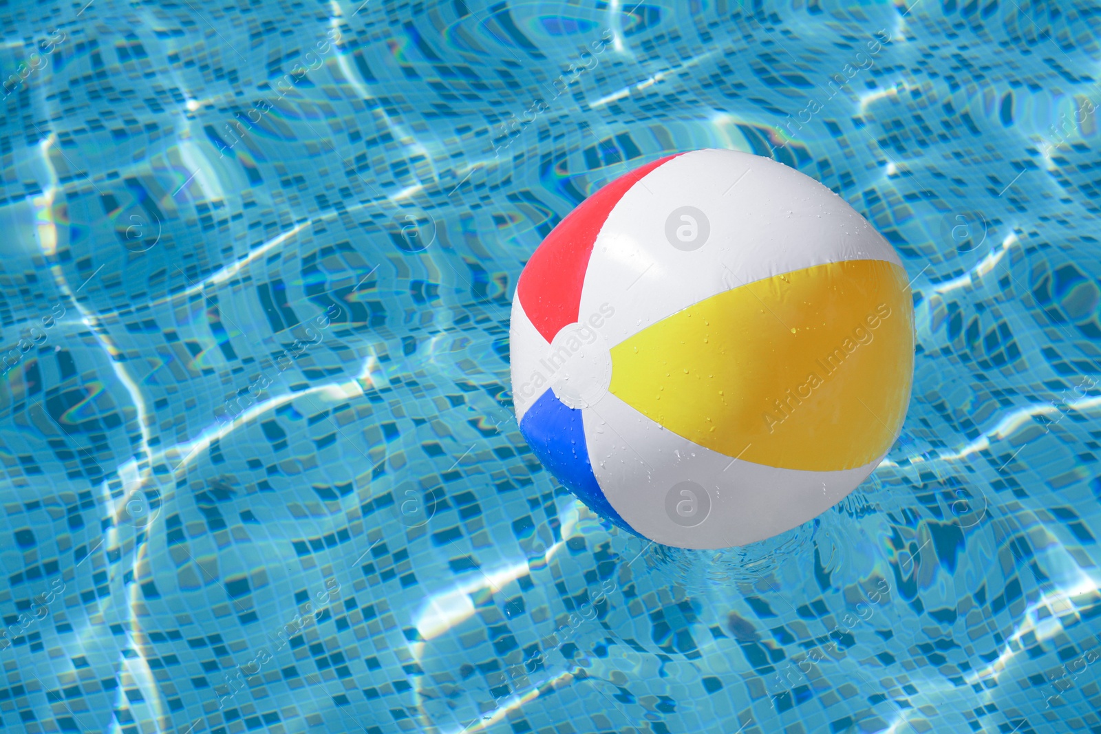 Photo of Inflatable beach ball floating in swimming pool, space for text