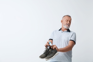 Photo of Man putting capsule shoe freshener in footwear on white background. Space for text