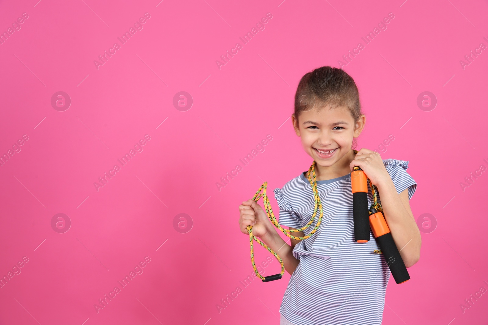 Photo of Cute girl with jump rope on color background. Space for text