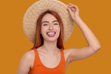 Happy woman showing her tongue on orange background