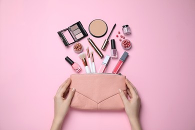 Woman with bag and decorative cosmetics on pink background, top view