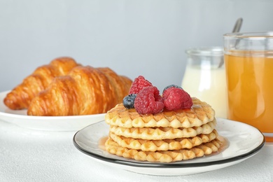 Delicious breakfast served on white table against light background