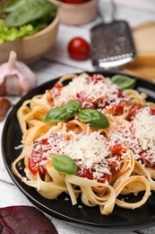 Photo of Delicious pasta with tomato sauce, basil and parmesan cheese on white wooden table, closeup