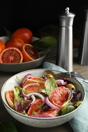 Photo of Bowl of delicious sicilian orange salad on wooden table. Space for text
