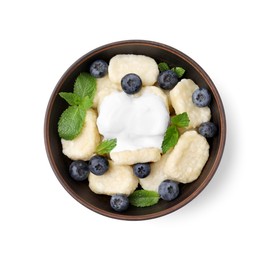 Photo of Bowl of tasty lazy dumplings with blueberries, mint leaves and sour cream isolated on white, top view