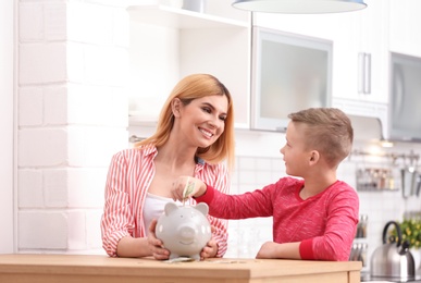 Photo of Family with piggy bank and money at home