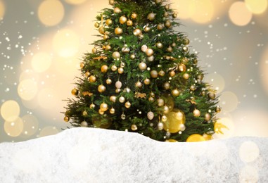 Image of Beautifully decorated Christmas tree and snow on light background. Bokeh effect