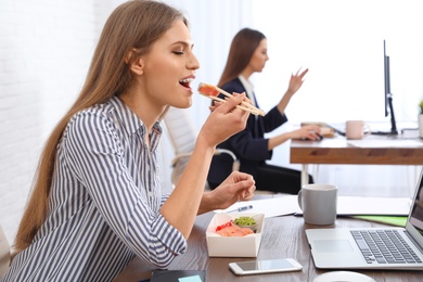 Photo of Office employee having lunch at workplace. Food delivery