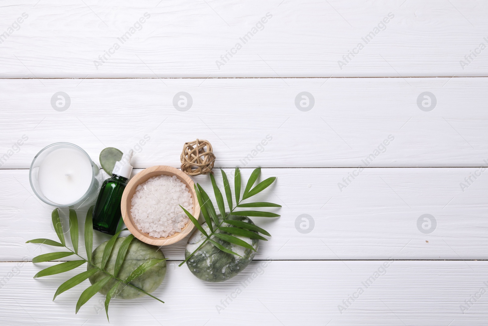 Photo of Flat lay composition with candle and different spa products on white wooden table. Space for text