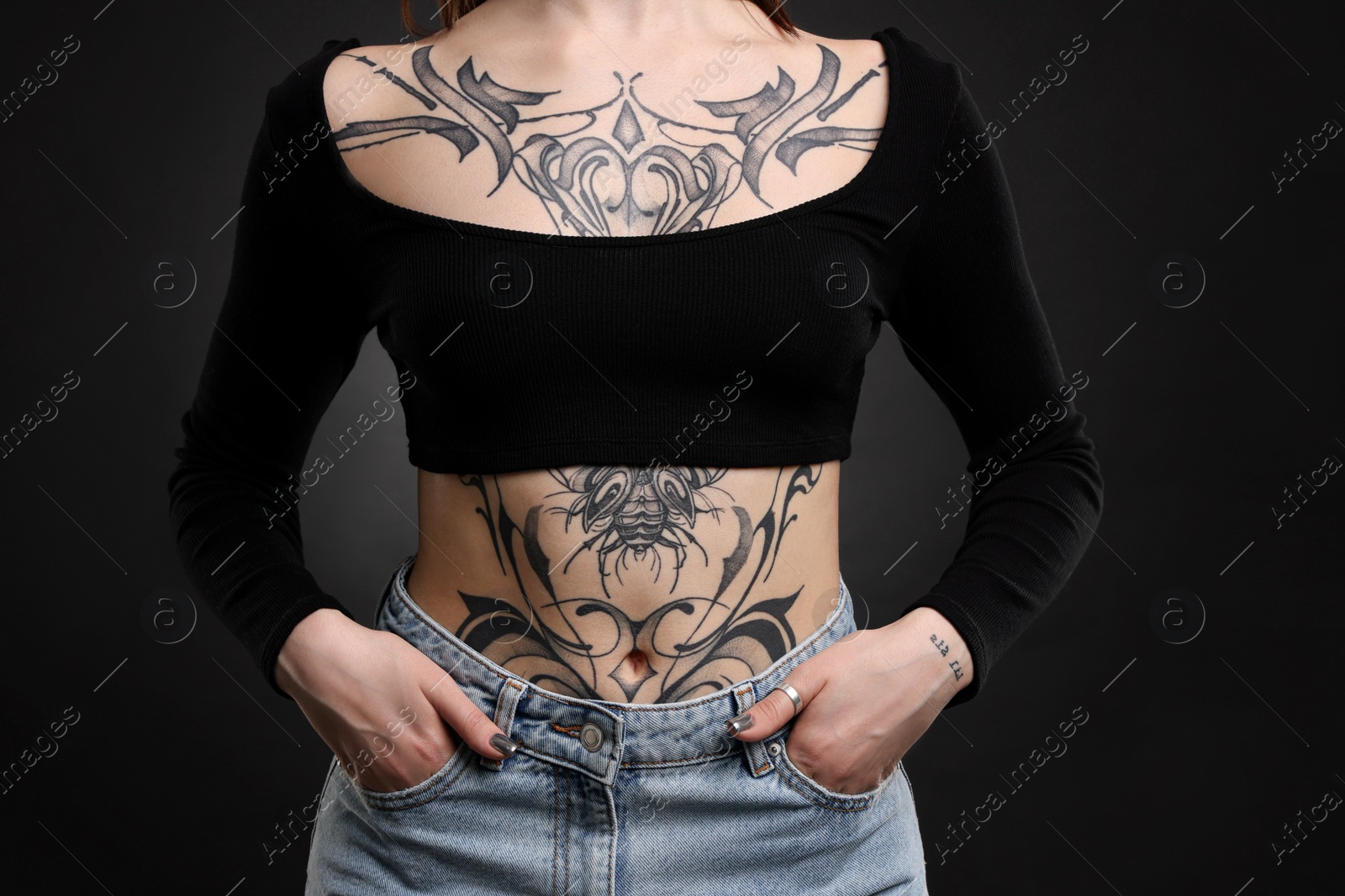 Photo of Woman with cool tattoos on black background, closeup