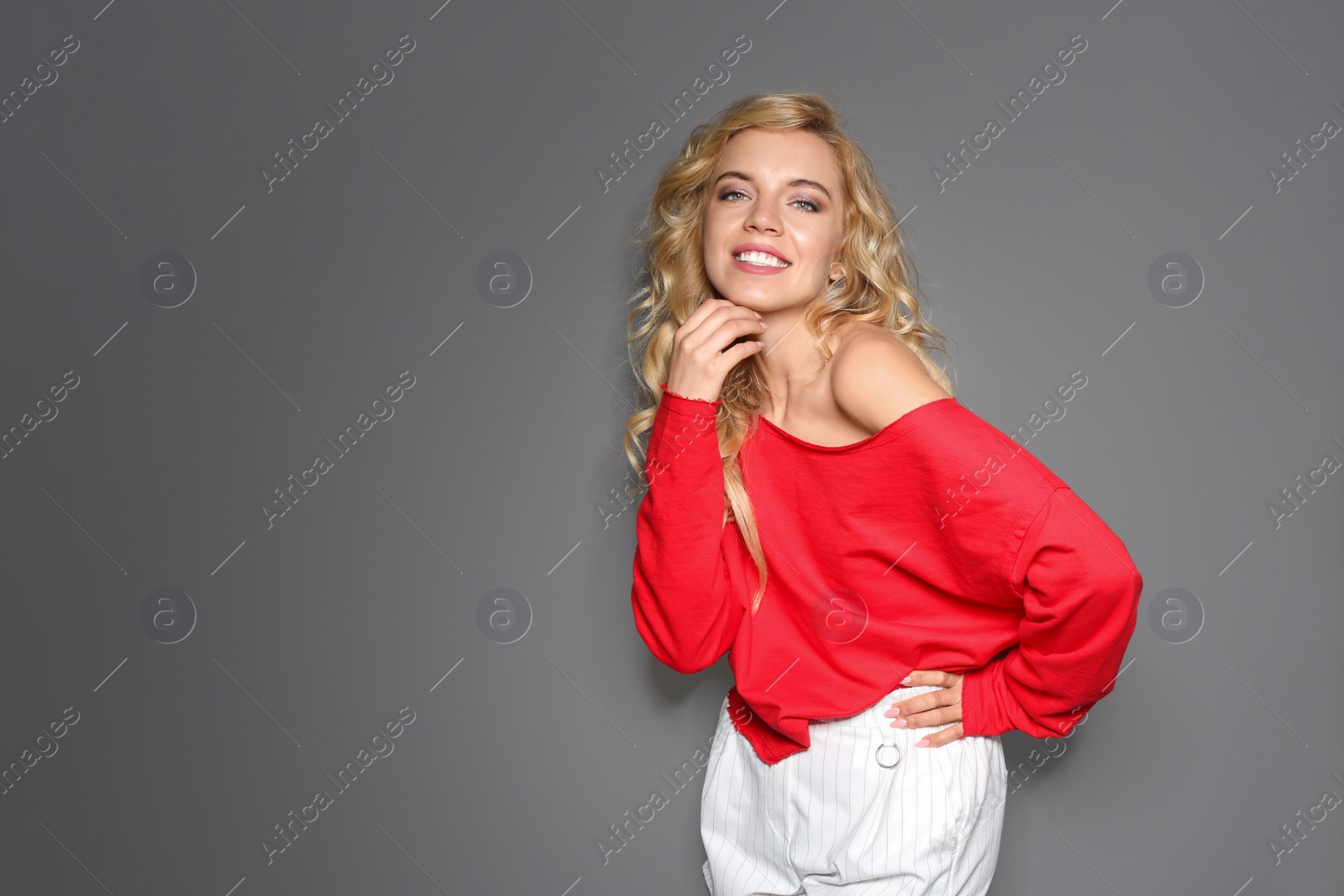 Photo of Stylish young woman posing on grey background