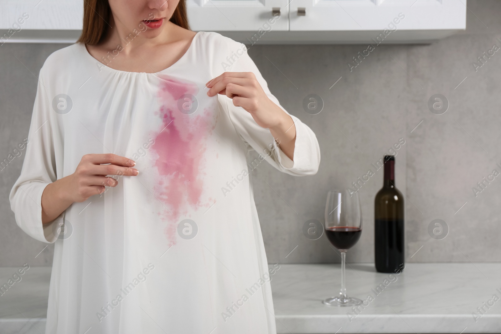Photo of Woman with wine stain on her clothes indoors, closeup. Space for text