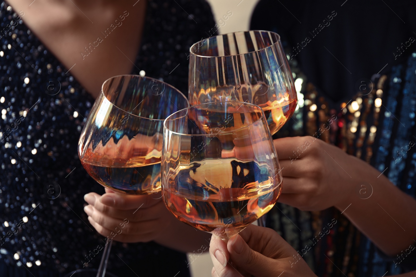 Photo of Women clinking glasses with white wine, closeup