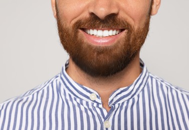 Photo of Smiling man with beard on grey background, closeup