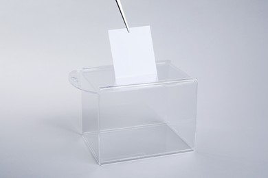 Photo of Ballot box with vote on light grey background. Election time