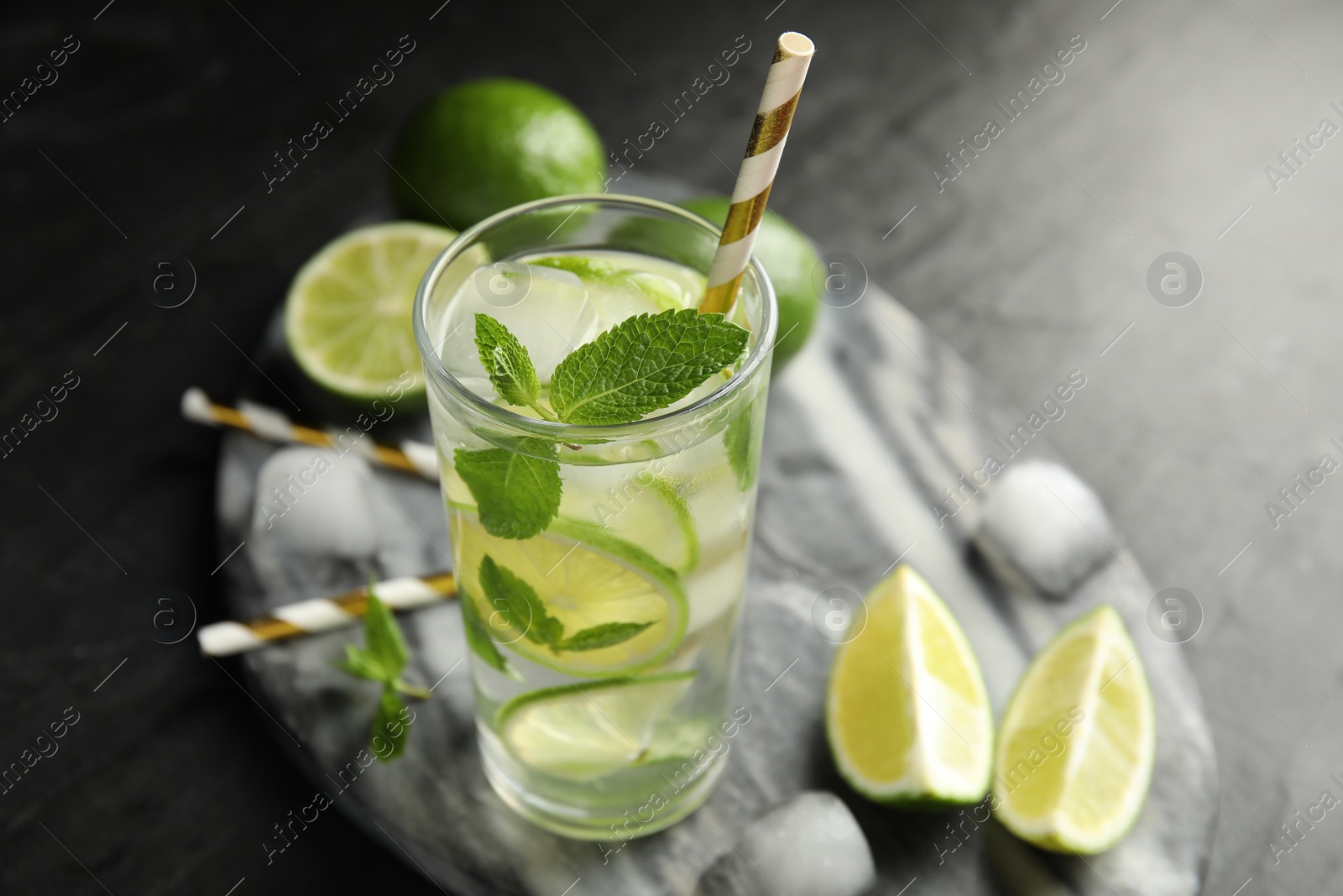 Photo of Delicious mojito and ingredients on black table