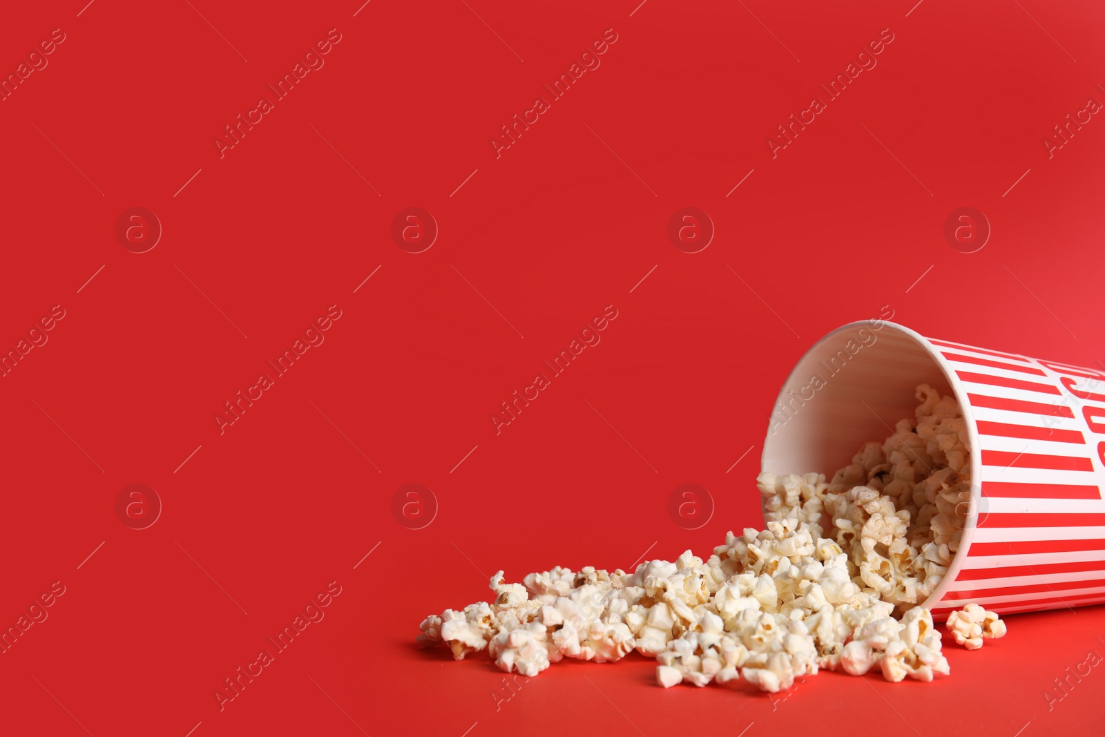 Photo of Tasty pop corn on red background. Space for text