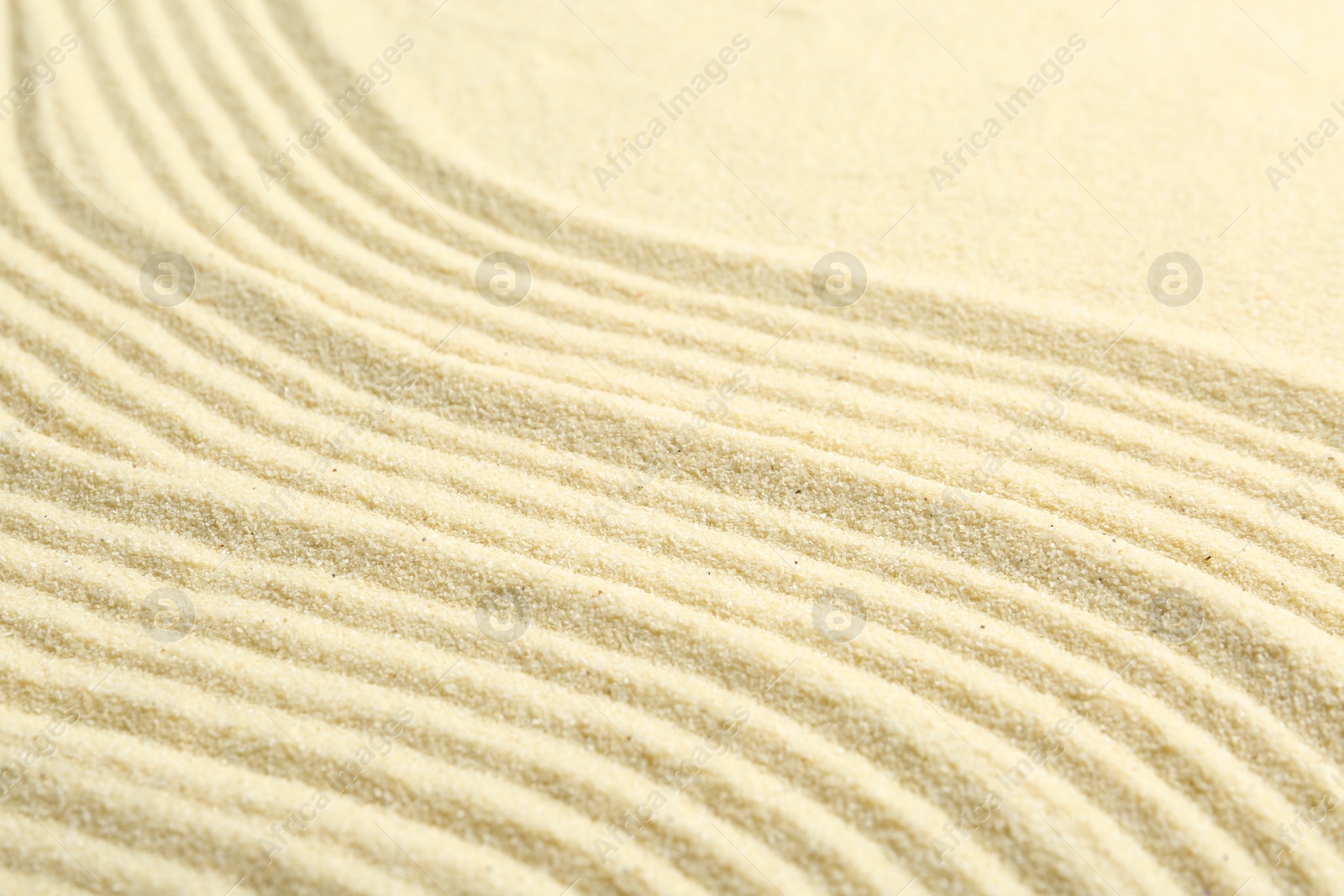 Photo of Zen rock garden. Wave pattern on beige sand