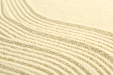 Photo of Zen rock garden. Wave pattern on beige sand