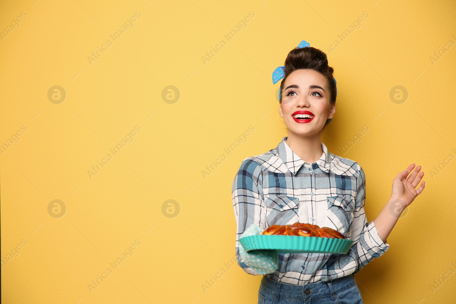 Photo of Funny young housewife with homemade pastry on color background