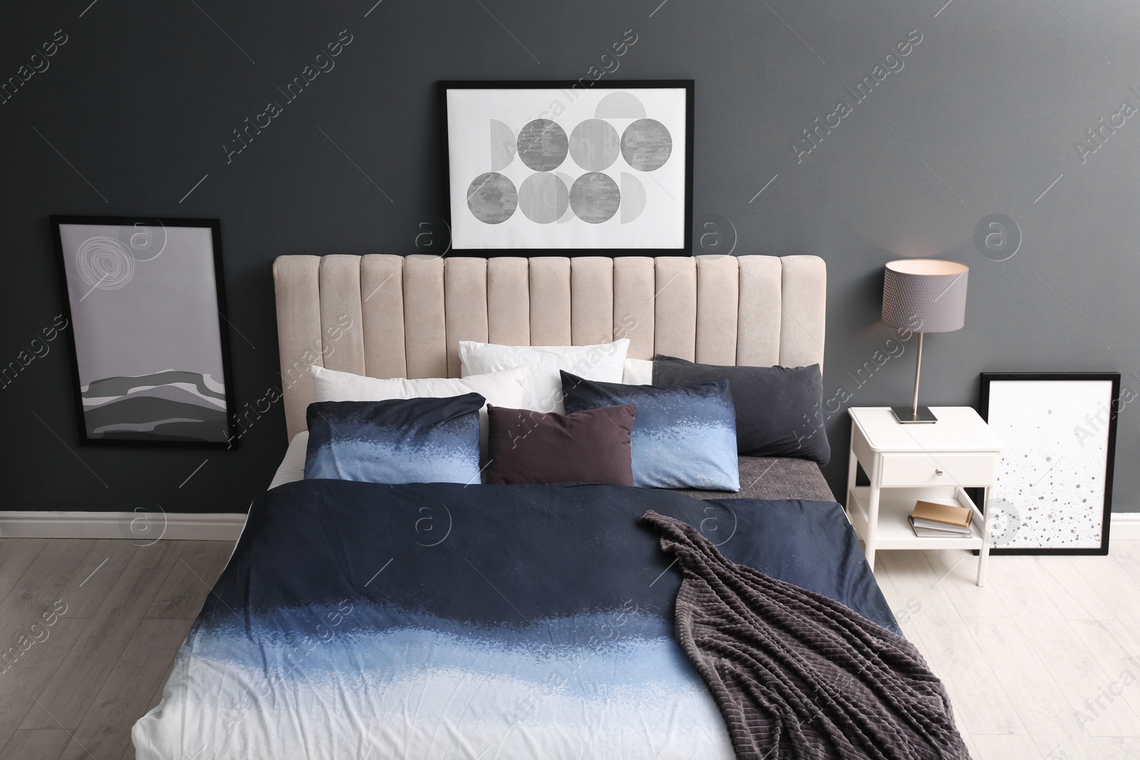 Photo of Comfortable bed with pillows and soft blanket in room. Stylish interior design