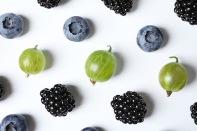 Composition with gooseberries, blackberries and blueberries on white background