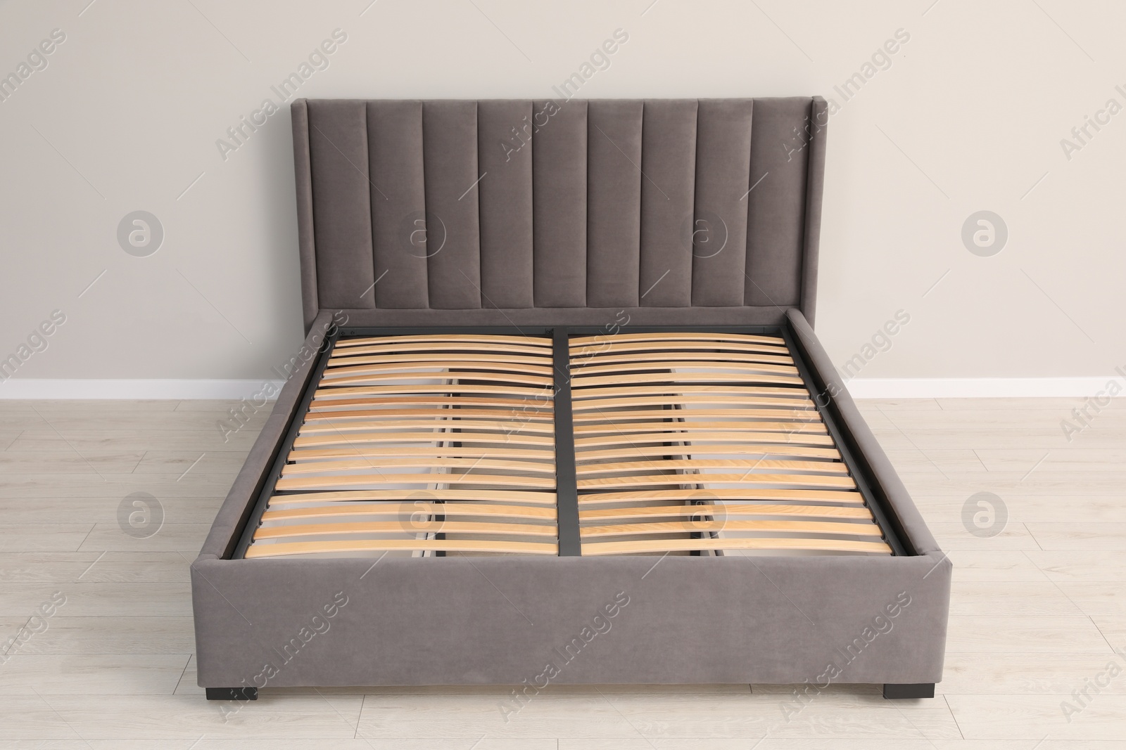 Photo of Comfortable bed with storage space for bedding under slatted base in room