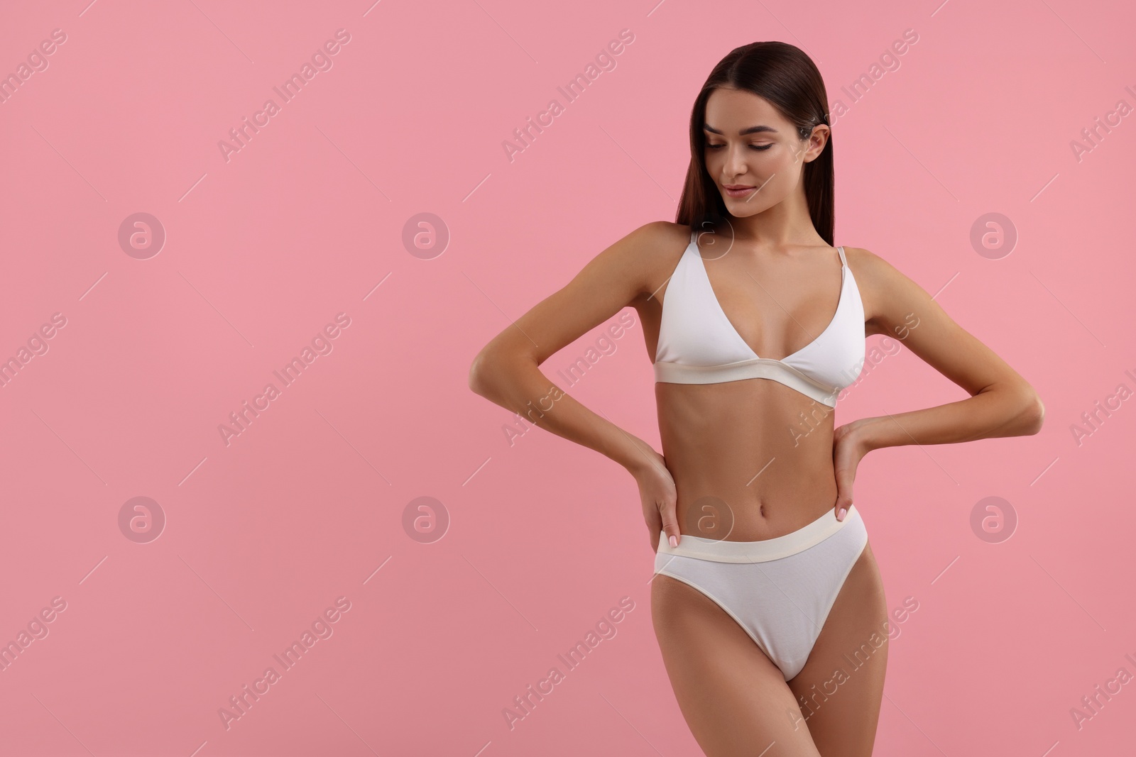 Photo of Young woman in stylish white bikini on pink background. Space for text