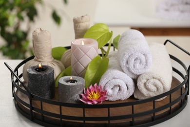 Composition with different spa products and burning candles on white table