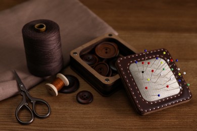 Photo of Set of sewing supplies and accessories on wooden table