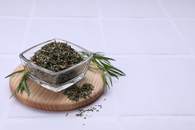 Photo of Dry and fresh tarragon on white tiled table, space for text