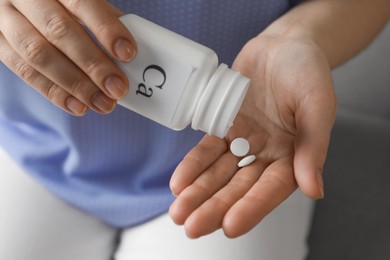 Photo of Calcium supplement. Woman taking pills indoors, closeup