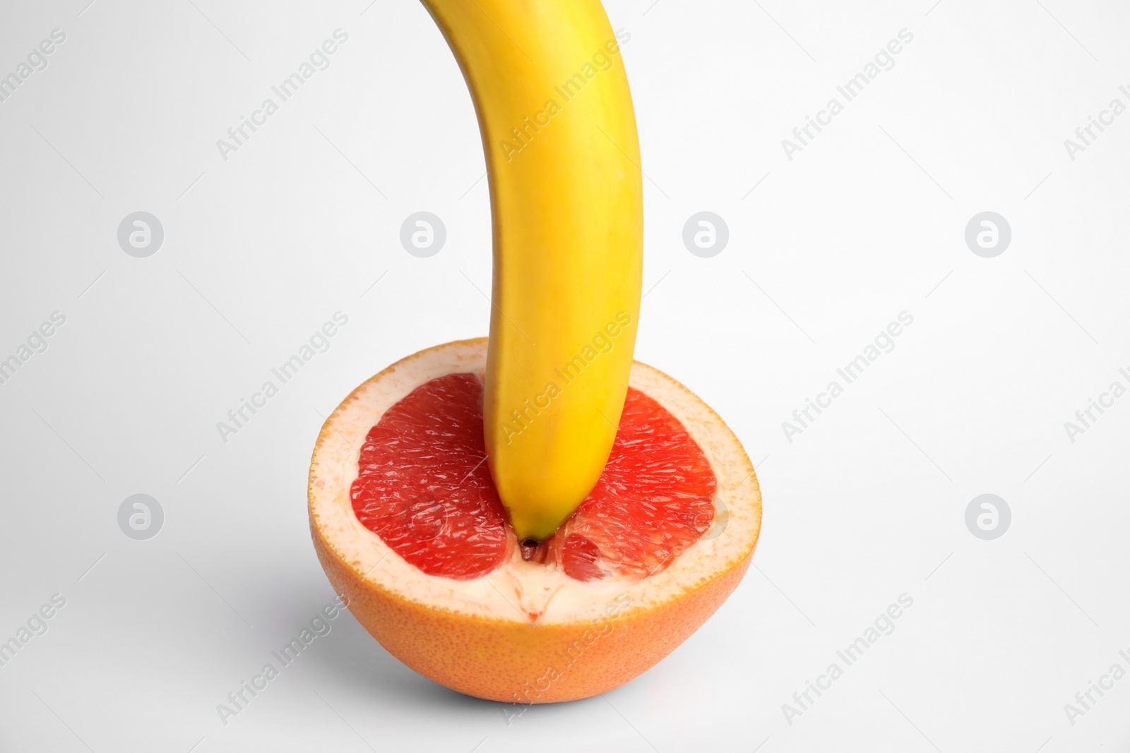 Photo of Fresh grapefruit and banana on white background. Sex concept