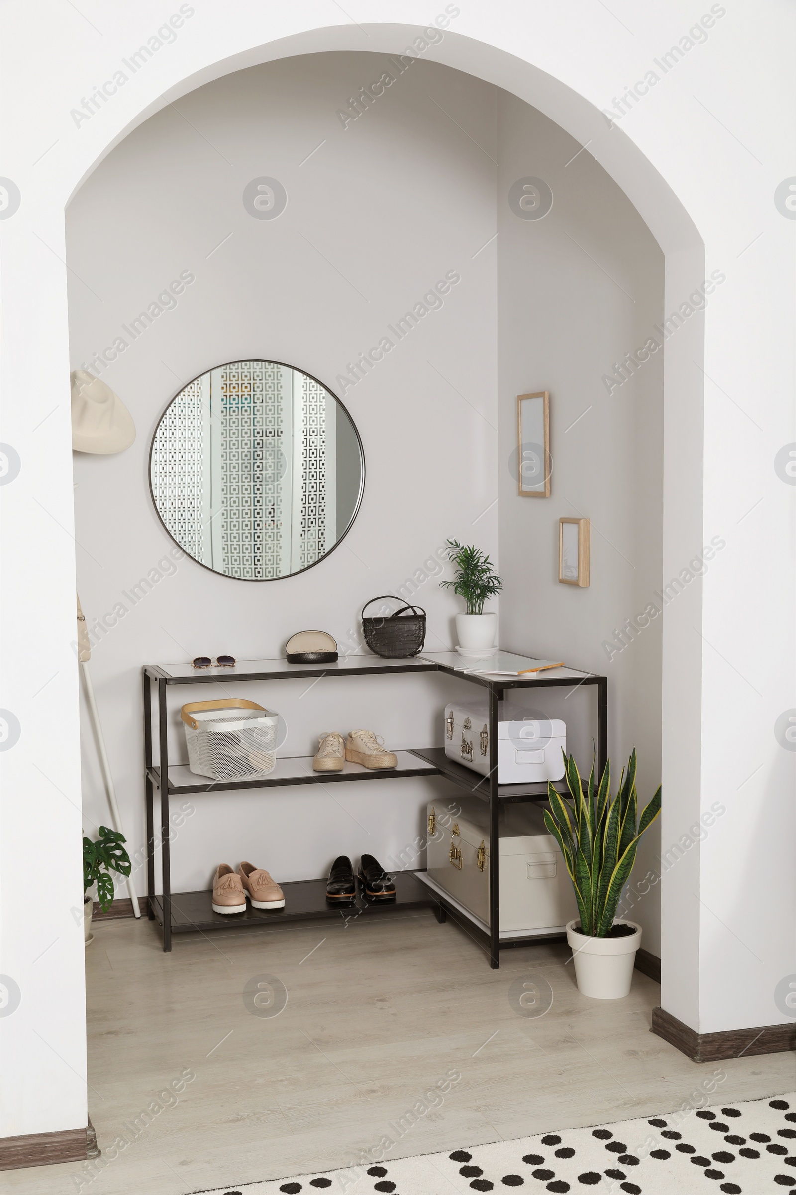 Photo of Hallway interior with stylish furniture and round mirror on light wall