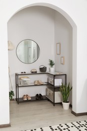 Photo of Hallway interior with stylish furniture and round mirror on light wall