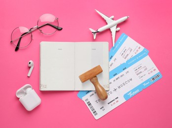 Photo of Flat lay composition with passport, stamp and flight tickets on pink background