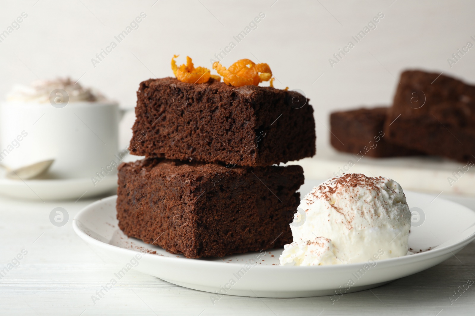 Photo of Plate with fresh brownies and ice-cream on table. Delicious chocolate pie