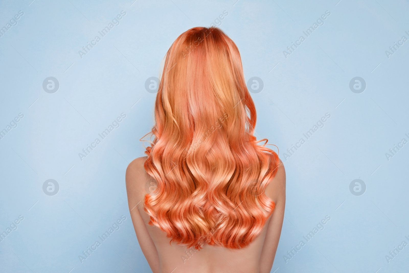 Image of Beautiful woman with long orange hair on light blue background